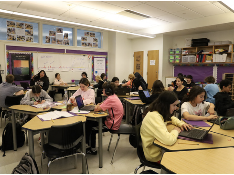 Clinton students sit inside a cold classroom wearing sweatshirts in May